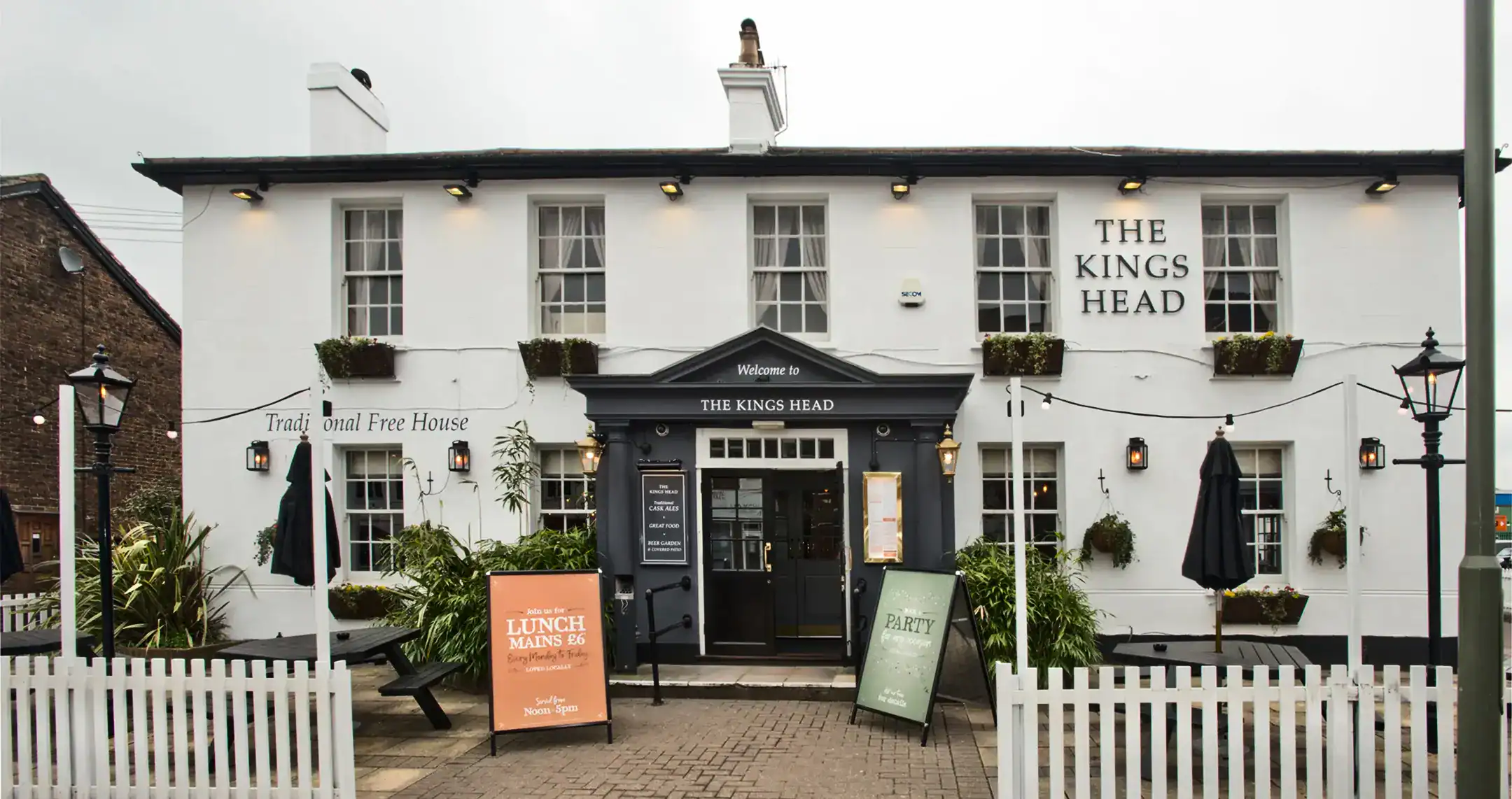 The Kings Head frontage with its picket fence, lamp post and outdoor seating