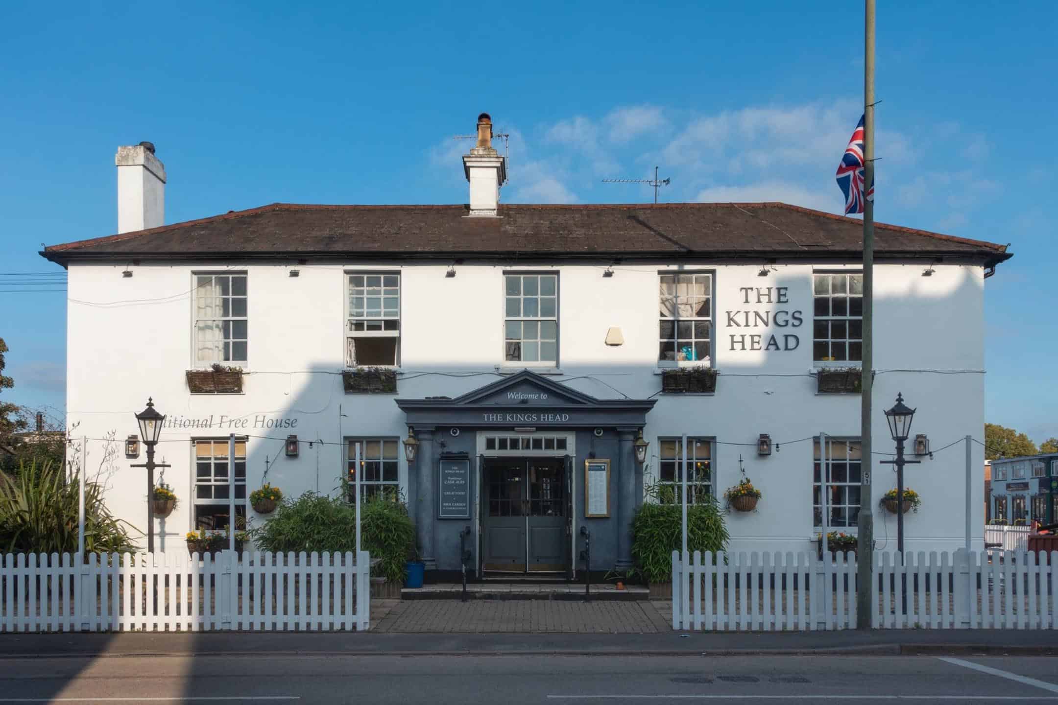 The white corner frontage of the Kings Head under a blue sky